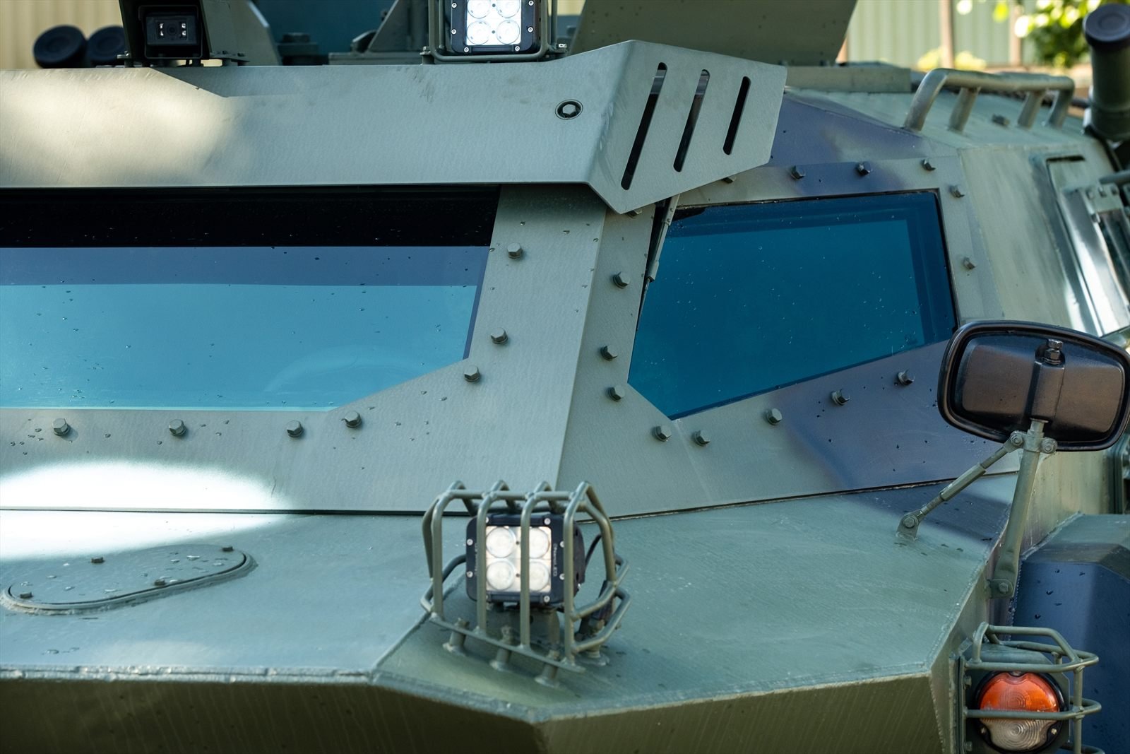 Front hull of an armored vehicle, with sloped plate, armoured vision blocks and caged work lights